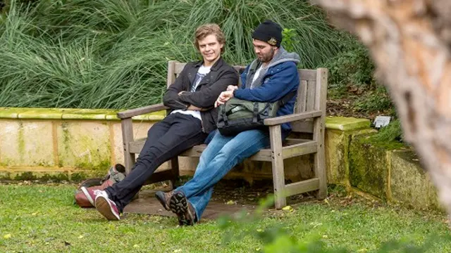 2 men sitting on a bench