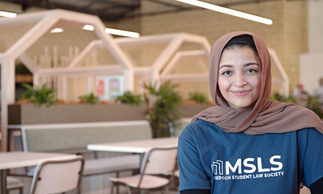 zahra smiling in blue murdoch student law society t shirt on the right side of the image