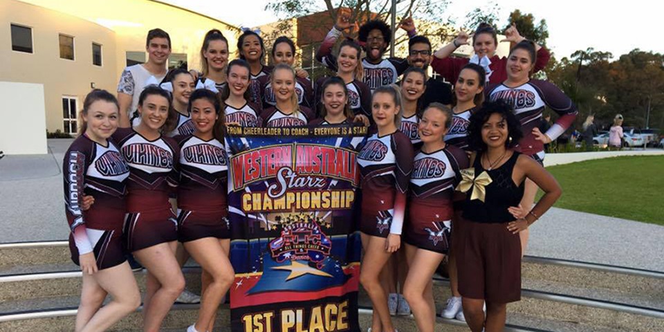 Alice Cignetti feature image 18 members of the Murdoch University Cheerleading Team in uniform, smiling and posing with a 1st place banner