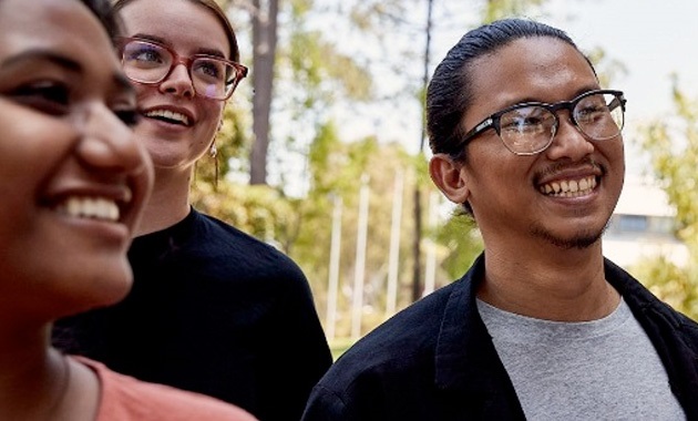 3 students smiling off camera