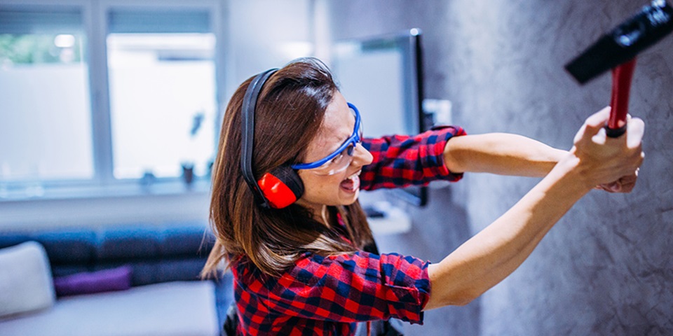 Broken feature Woman smashing wall with tool
