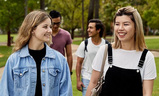 Students chatting while walking across campus