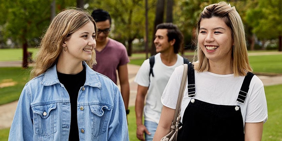 Students chatting while walking across campus