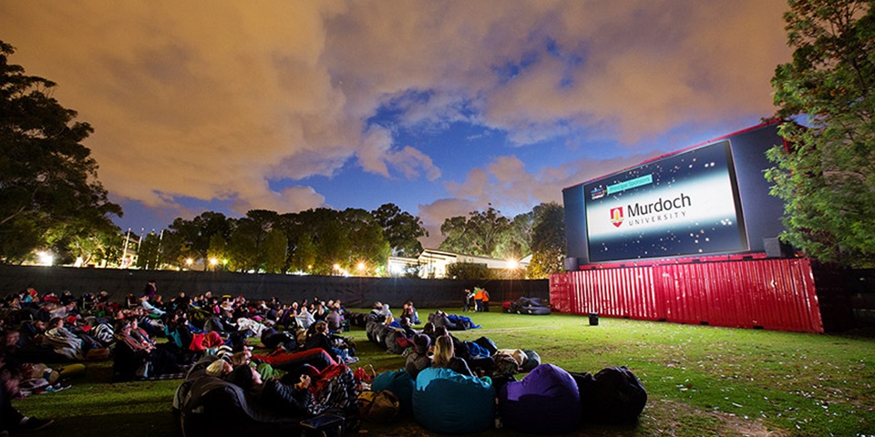 People sitting on beanbags at an outside cinema