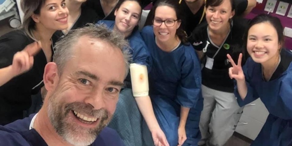 Cormac feature image 860 x 480 px A group of Murdoch nursing students in scrubs smile to camera with their lecturer