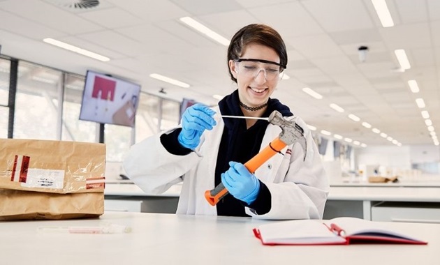 Student swabs hammer in a science lab