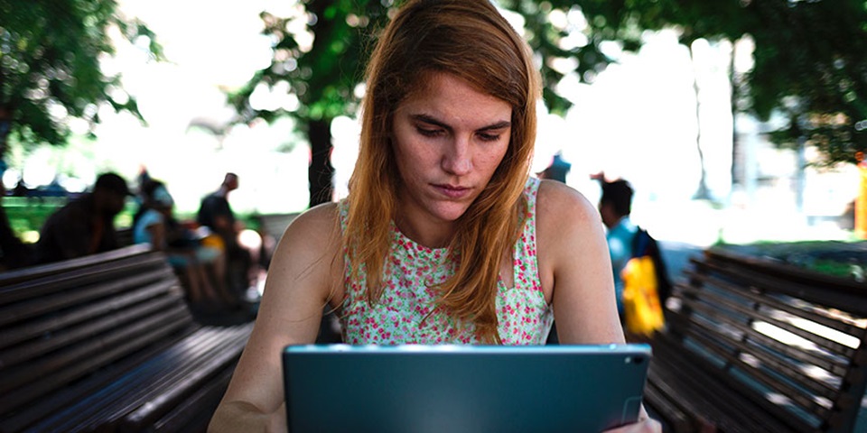 Girl researching on her laptop in a park