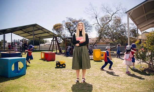 Teacher standing in primary school playground.