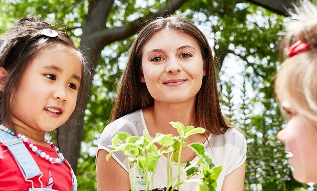 Young children with the teacher in the garden