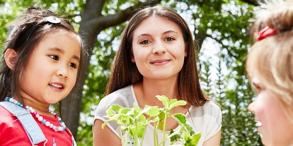 Five courses - feature Young children with the teacher in the garden