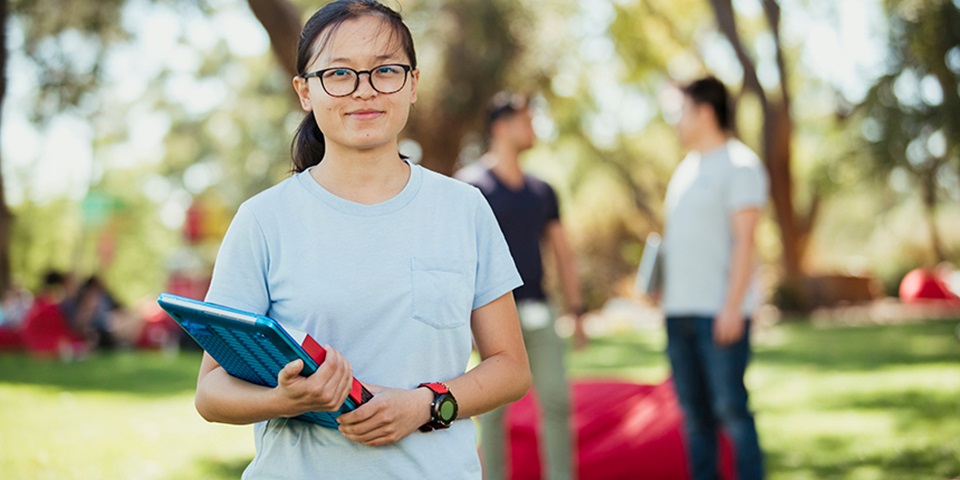 Girl holding folder smiling at camera feature Girl holding folder smiling at camera