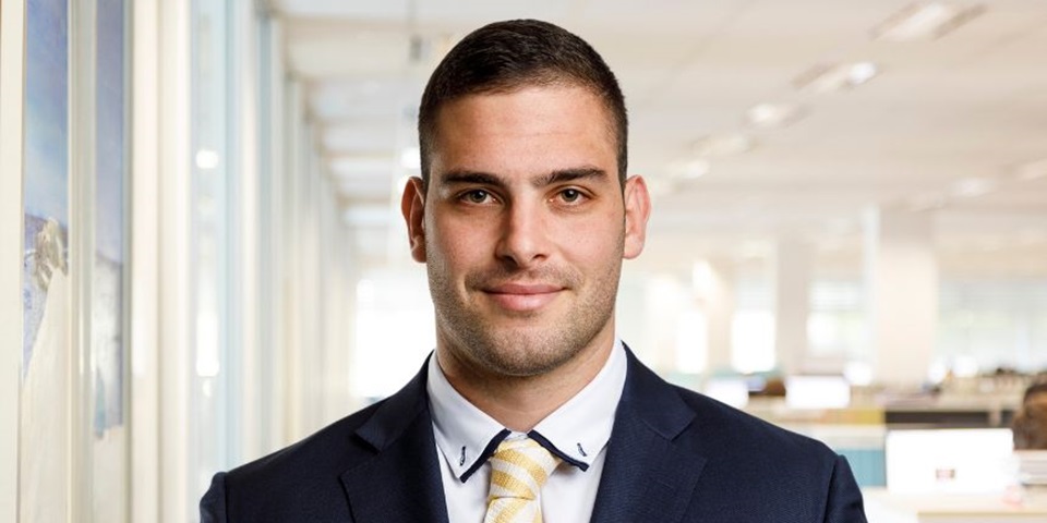 Student in suit smiles to camera