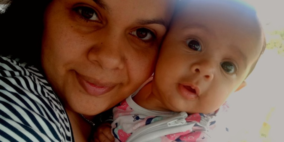 Close up photo of an Aboriginal mum cuddling her baby