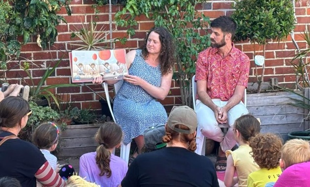 Katherine Alice and Yohann Devezy reading Don't Worry Felix to a group of children.