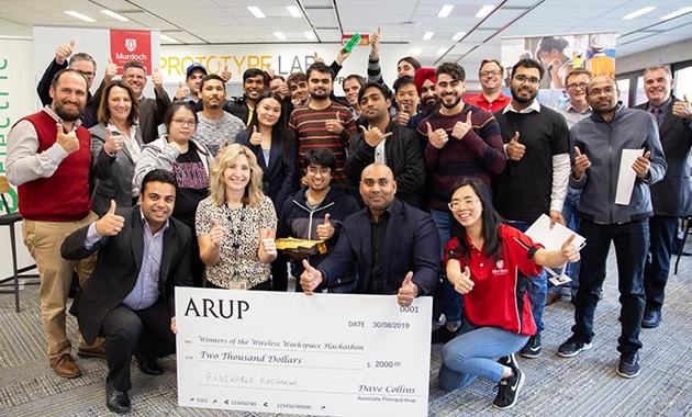 Group of people smiling and holding a big cheque