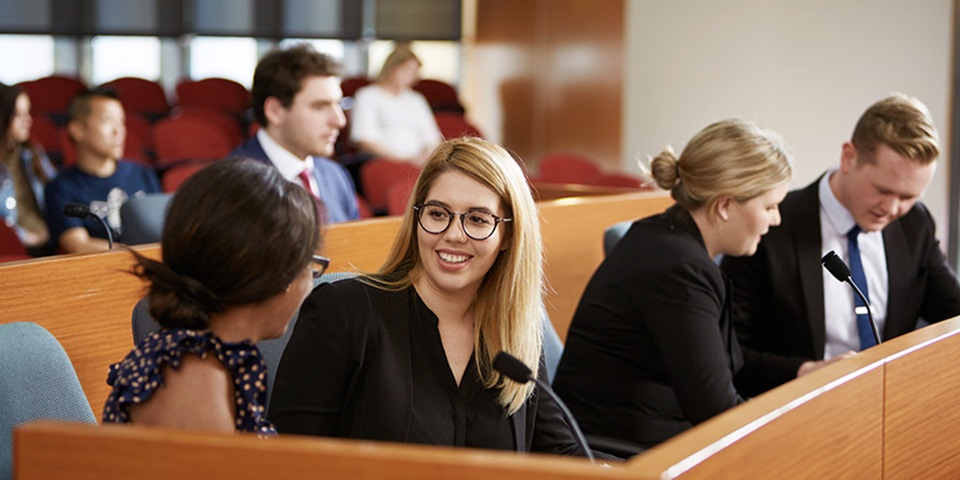 Law_Job_Feature Lawyers speak to each other in a court room.