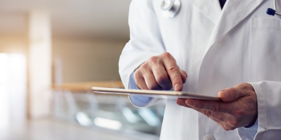 male doctor's hands on tablet