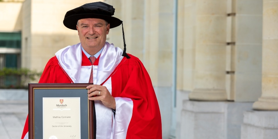 Dr Mathias Cormann holding his Honourary Doctorate