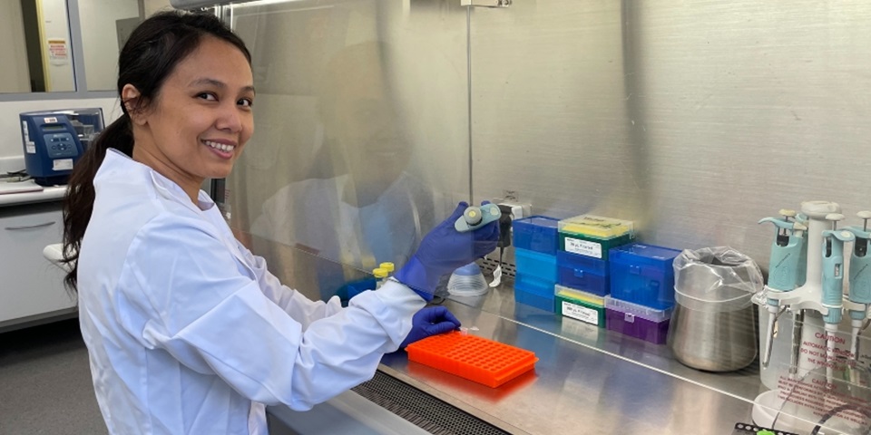 Dr May Aung-Htut smiles at camera while working in genomics laboratory