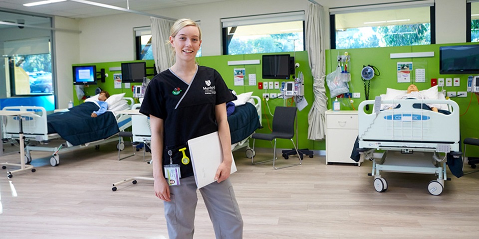 A Murdoch University nursing student stands in the simulated ward