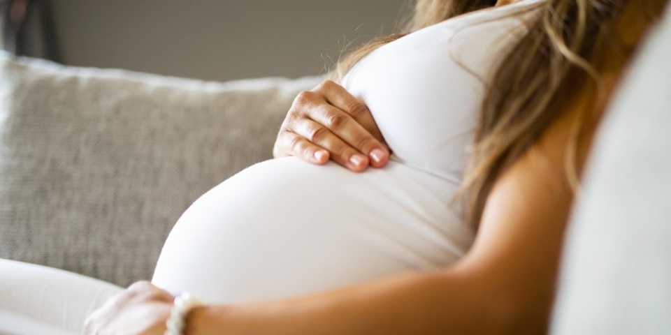 Woman with her hands over her pregnant belly