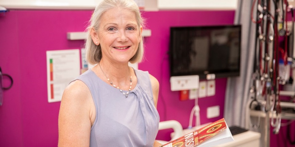Professor Anne Williams holding a book