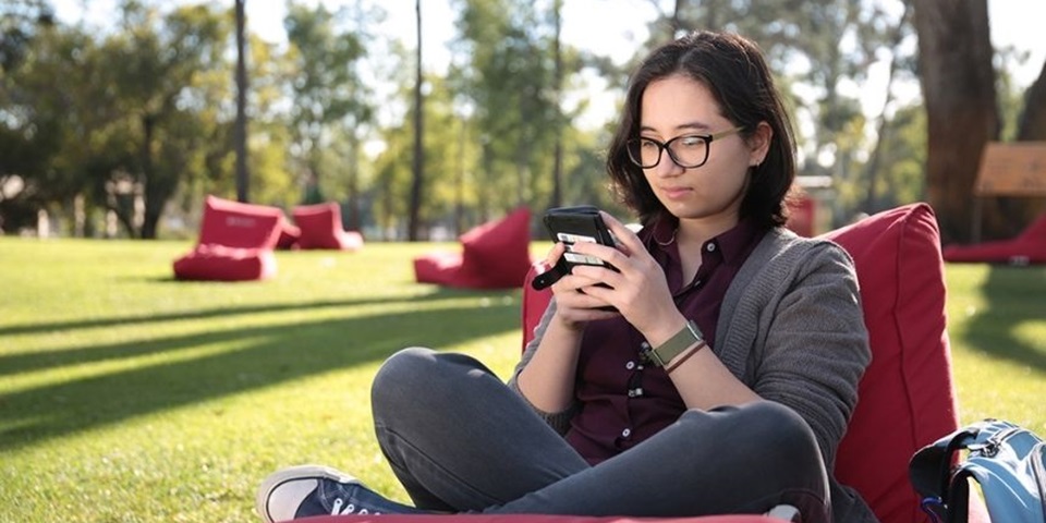Shy teen feature 860x480 Teenager sitting outside by themselves on their phone