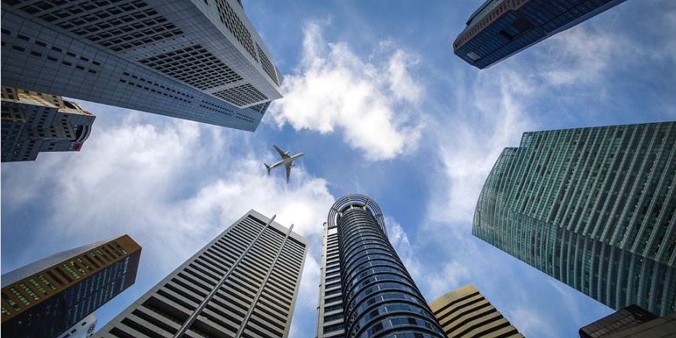 A plane flying over buildings in Singapore