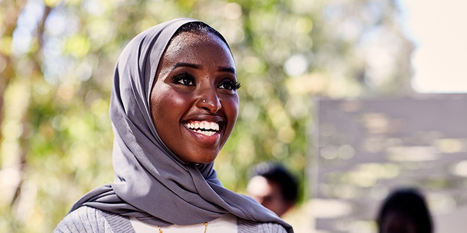 Social_Job_Feature Female student wearing hijab smiling.