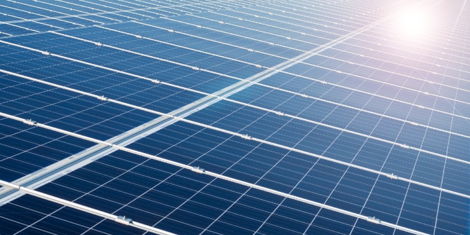 solar panels with sun reflecting on them