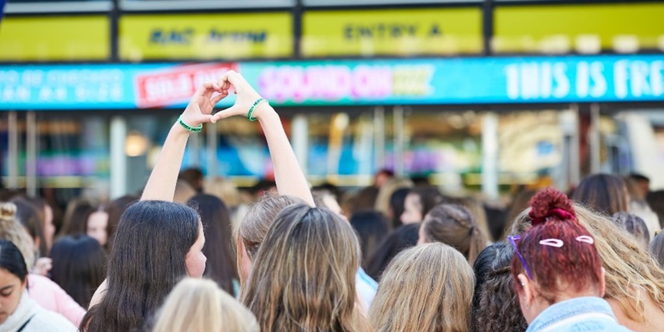 two girls at sound on festival in the crowd lining up