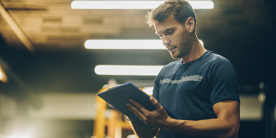 Strength-and-Conditioning-Coach-Feature Strength and conditioning coach assessing training in the gym