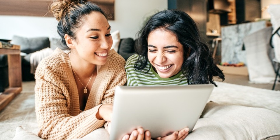 Students keeping in touch with relatives feature Two girls looking at their iPad