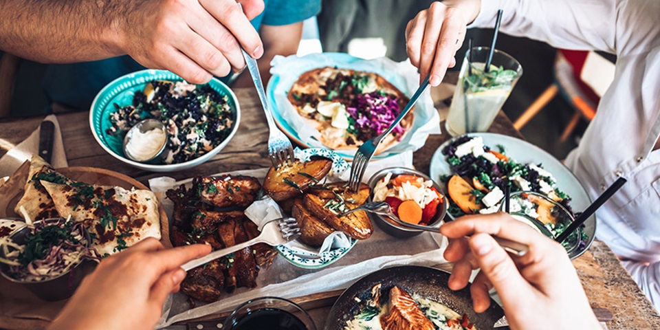 Taste of home in Perth feature Friends gathered around a table with vibrant food