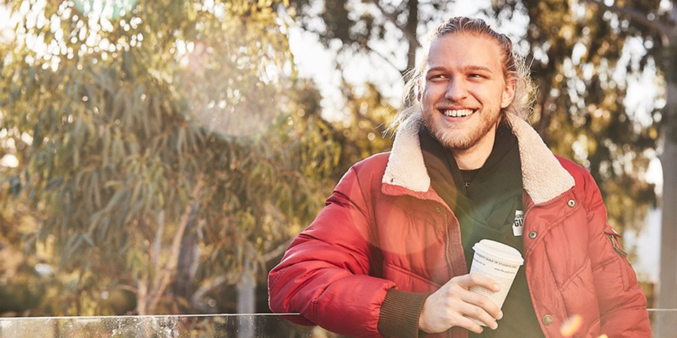 Transferring unis feature image Murdoch student wearing red jacket and smiling
