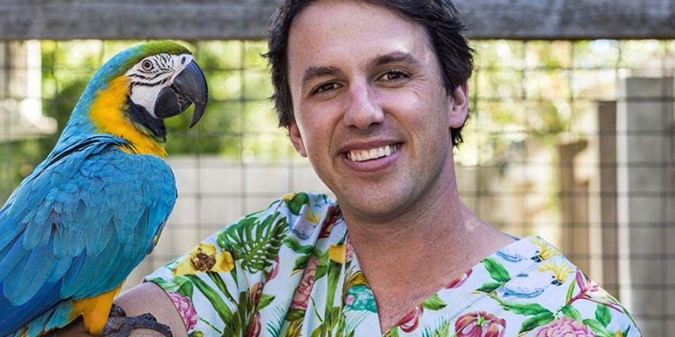 Veterinary surgeon Dr James Haberfield with a macaw on his shoulder