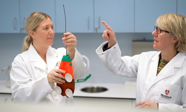 Vice Chancellor Eeva Leinonen in lab coat with scientist