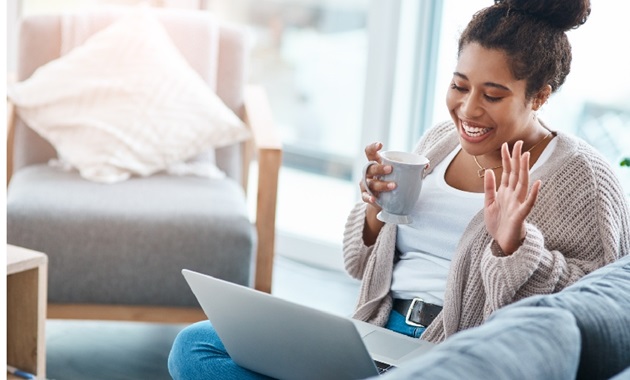 A young lady has fun with family and friends by video calling them on her laptop