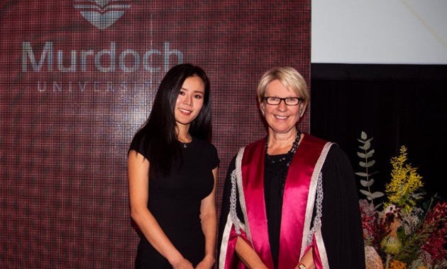 Wenna Lee and Vice Chancellor Eeva Leinonen stand in front of a banner at the VC awards