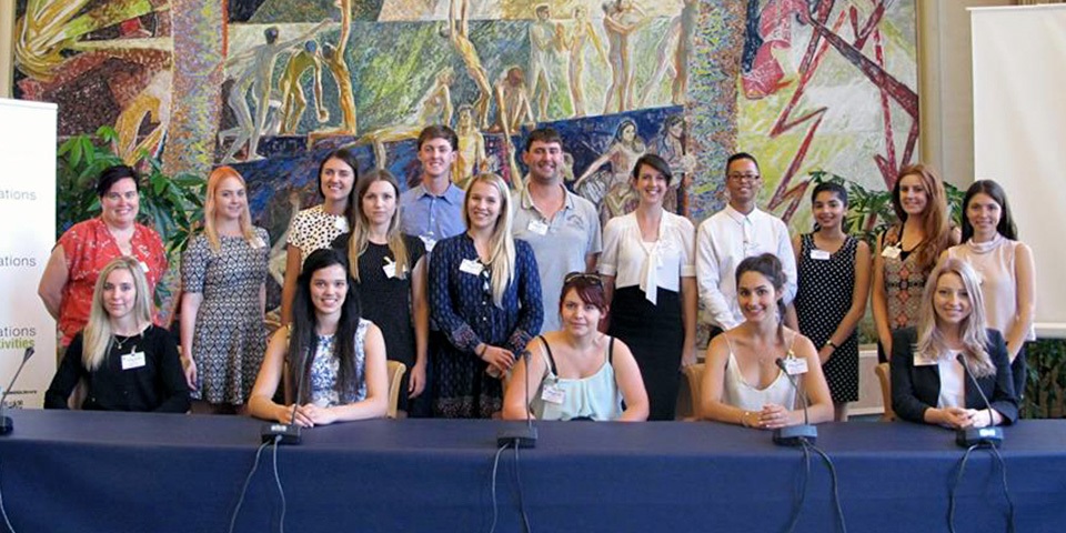 Students posing as a group at a table