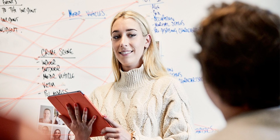 Student with Ipad in front of whiteboard